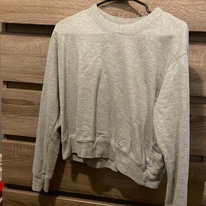 Grey long sleeve crop shirt, with a crew neck top.